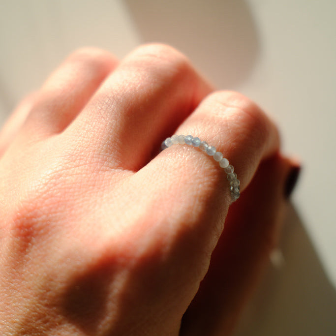 Close-up of a hand wearing a delicate ring with a blurred background